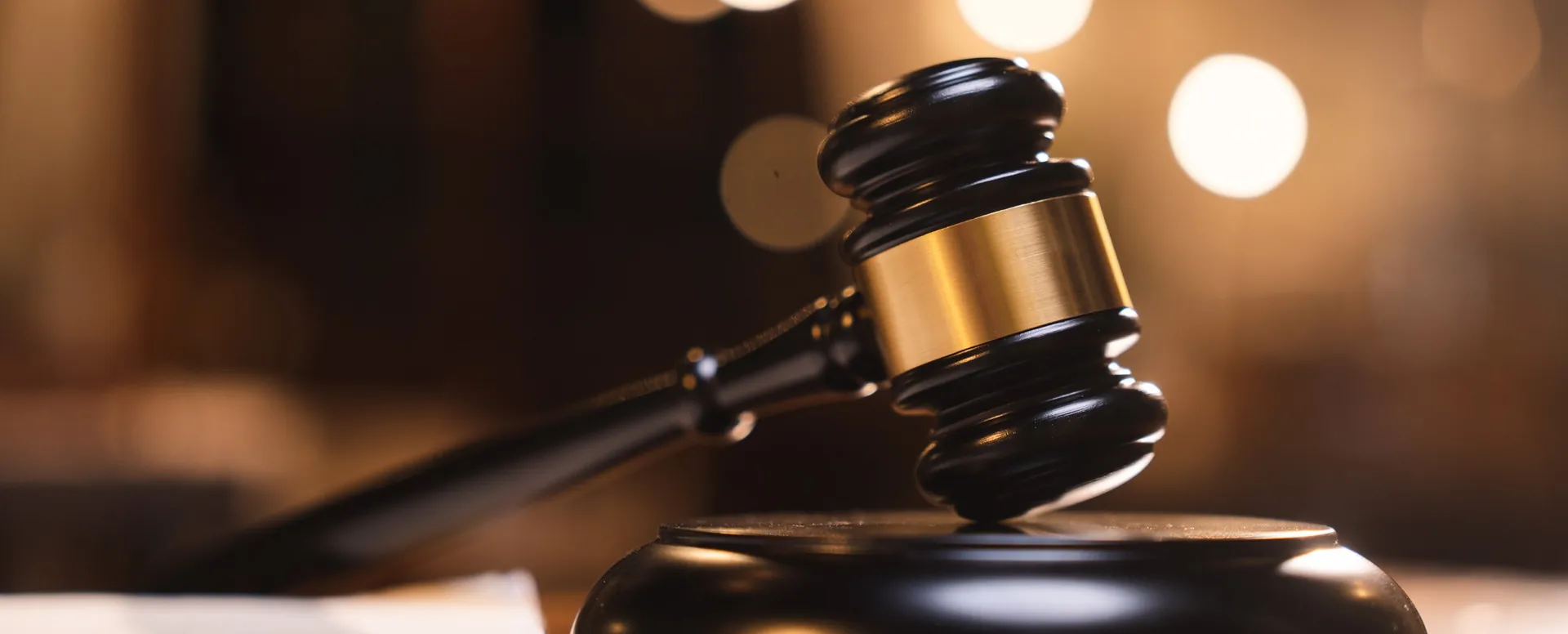 A gavel on its block in a warmly lit courtroom