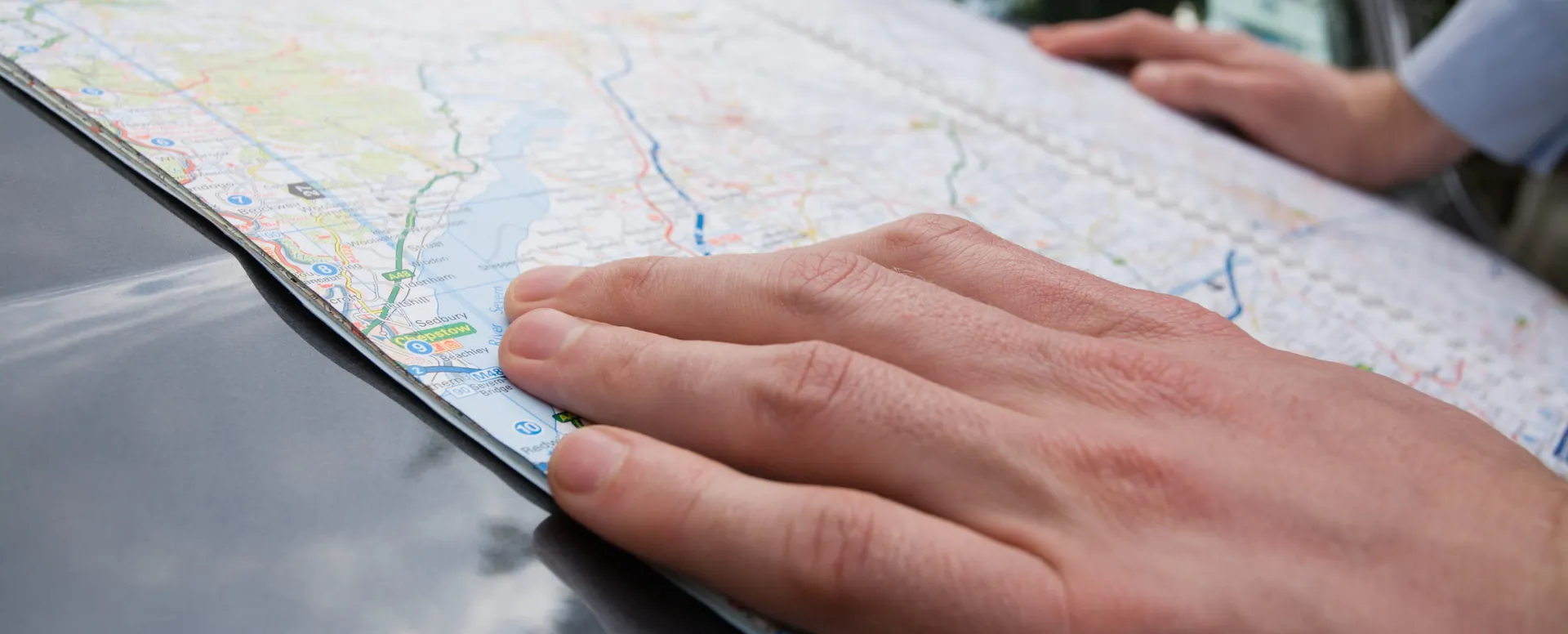 A hand resting on an open road map